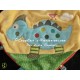 Doudou dinosaure bleu sur carré jaune vert revers rouge 4 noeuds NICOTOY